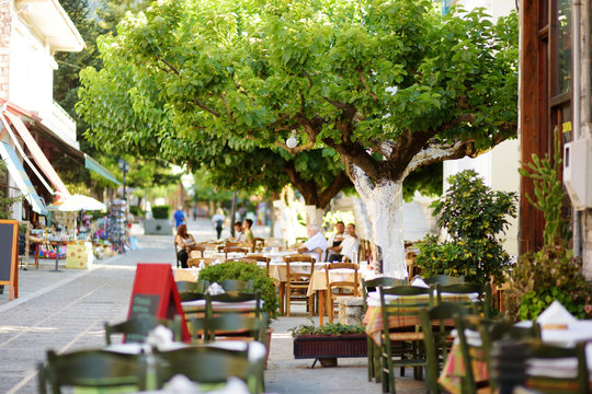 Fototapeta Small outdoor restaurants at the pedestrian area at center of Kalavryta town near the square and odontotos train station, Greece.