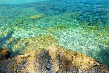 Scenic view of Emplisi Beach, picturesque stony beach in a secluded bay, with clear waters popular for snorkelling. Small pebble beach near Fiscardo town of Kefalonia, Greece.