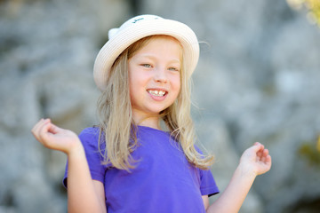 Cute young girl having fun outdoors on warm and sunny summer day during family vacations in Greece