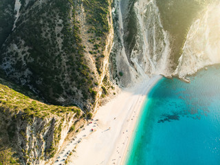 Aerial view of Myrtos beach, the most famous and beautiful beach of Kefalonia, a large coast with turqoise water and white coarse sand, surrounded by steep cliffs.