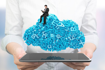Big data and cloud computing concept. Woman hands holding digital tablet with working businessman sitting on cloud of blue letters and numbers, front view.