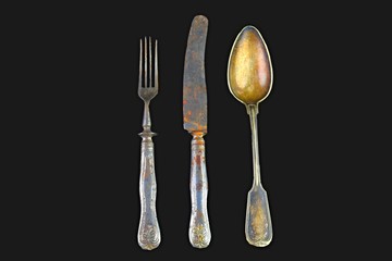 Vintage cutlery on a black background. Top view. Crazy concept for culinary and modern life. Contrast between shabby cutlery and excellent modern color. Free space for text 