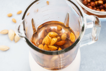 Blender with soaked almonds for making nut milk.