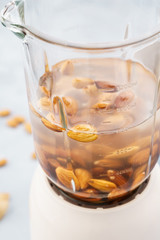 Blender and almonds soaked in water. Making vegan milk.