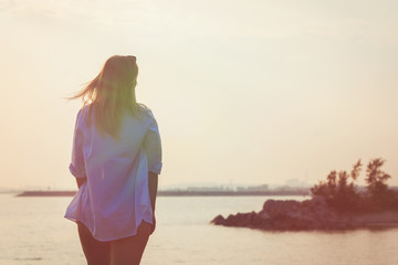 Beautiful girl stands on the rocks.