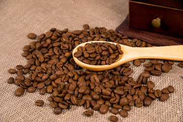 Coffee beans with wooden spoon and coffe grinder