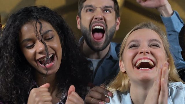 Group of fans emotionally cheering for favorite football team victory in pub