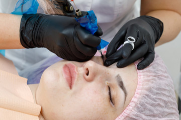 Permanent makup on face, woman having eyelid tattoo