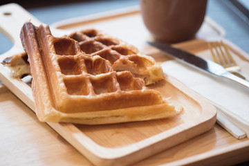 Grilled waffles with bacon on wooden tray