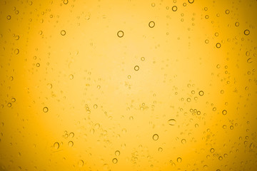 Water drops on yellow glass, Rain droplets on glass background.