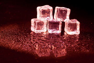 Red ice cubes on black background.