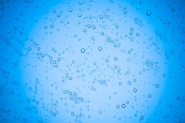 Rain droplets on blue glass background, Water drops on glass.