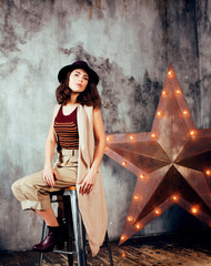 young pretty woman waiting alone in modern loft studio, fashion clothers wearing hat, lifestyle and...