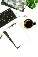 Flat lay top view office desk with laptop,  accessories, notebook, glasses, cup of coffee on white background. Copy space