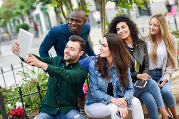 Multi-ethnic young people taking selfie together in urban background