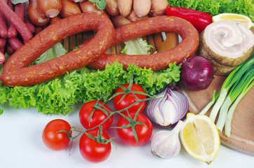 Meat products, sausage, ham, decorated with vegetables and spices on the table