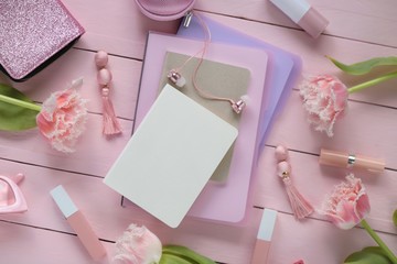 Spring fashion Flat lay.Spring to-do list.a pile of notebooks,  fashion accessories, cosmetics and  pink tulips on a pink  board background.top view, copy space
