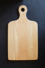 Wooden cutting board on black background