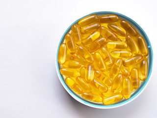 Top view of fish oil in white bowl on white table. Fish oil vitamin brain