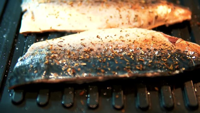 Fresh Fish Fried On Grill With Seasoning. Mackerel Being Grilled.A Steak Of Fresh Fish Is Fried On A Hot Grill With Aroma And Smoke.Fish Cooked On The Grill.Macro Fried Grill Fish With Spice.