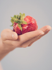 Fresh red strawberry on palm