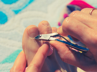 Woman trimming cuticles before pedicure