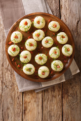 Freshly made potato dumplings with bacon and green onions close-up on a plate. Vertical top view
