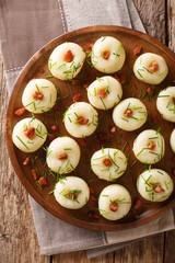 Homemade round potato dumplings with bacon and green onions close-up on a plate. Vertical top view