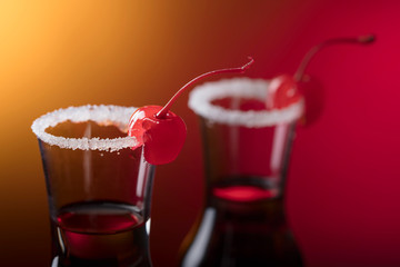 Cocktail garnished with cherry and sugar.
