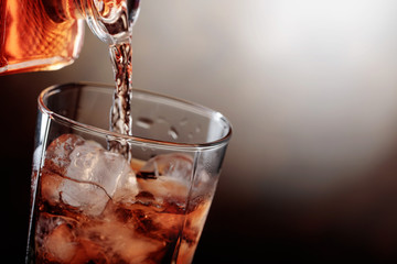 Whiskey is poured from a carafe into a glass .
