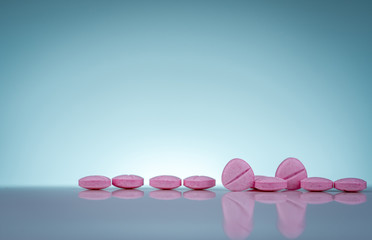 Pink tablets pills with shadow on gradient background. Pharmaceutical industry. Pharmacy products. Vitamins and supplements. Medication use in hospital or drugstore. Global drug retail market.