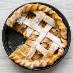 Top view, home-baked apple pie on white wooden surface. Flat lay, overhead, from above. Close-up.