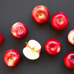 Top view, fresh raw red apples on black surface. Flat lay, overhead, from above. Close-up.