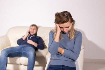 domestic violence, abuse and family concept - crying woman and her husband on the background