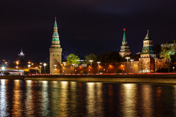 Obraz premium Towers of Moscow Kremlin with glowing reflection of night illumination on water surface of Moskva river