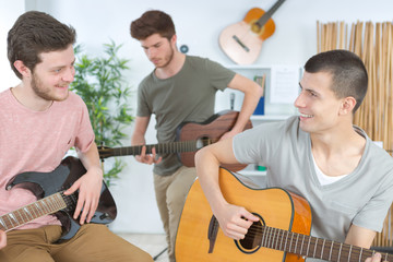 young men composing music for guitarist