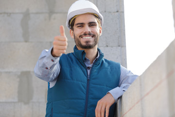 happy builder man laughing and making thumbs up at camera