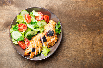 Grilled chicken breast. Fried chicken fillet and fresh vegetable salad .