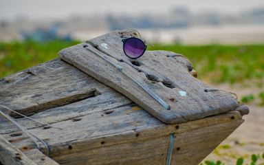 Abandoned broken sunglass on a wooden structure.