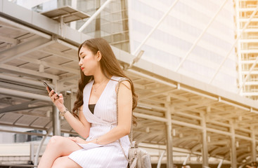 Unemployment problem concept,Asian beautiful woman connection internet find new job on cell phone while sitting outdoor