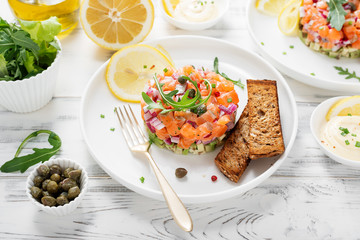 Salmon tartare with red onion, avocado, arugula and bread toast.
