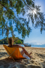 Woman enjoying her holidays on a transat at the tropical beach