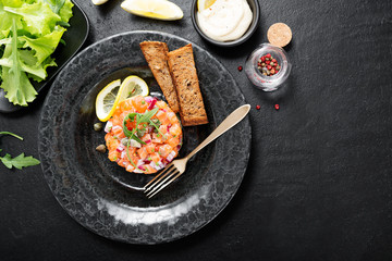 Salmon tartare with red onion, avocado, arugula and bread toast.