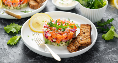 Salmon tartare with red onion, avocado, arugula and bread toast.