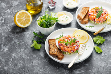 Salmon tartare with red onion, avocado, arugula and bread toast.