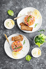 Salmon tartare with red onion, avocado, arugula and bread toast.