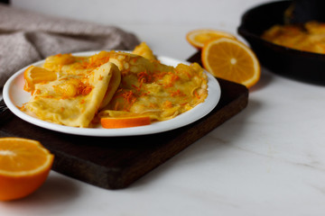 Traditional French crepes Suzette with orange sauce on white plate