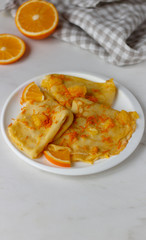 Traditional French crepes Suzette with orange sauce on white plate. Copyspace for your text