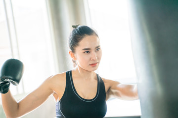 Young asian women doing boxing training with punching bag