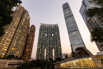 Tall modern apartment buildings tower over urban landscape at sunset